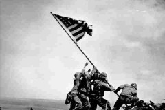 Marines and one Navy sailor raise the American flag at Mt. Suribachi. (File Photo)
