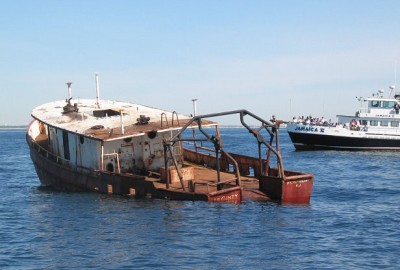The deployment of a barge to make up an artificial reef off Manasquan Inlet. (Photo: NJDEP)