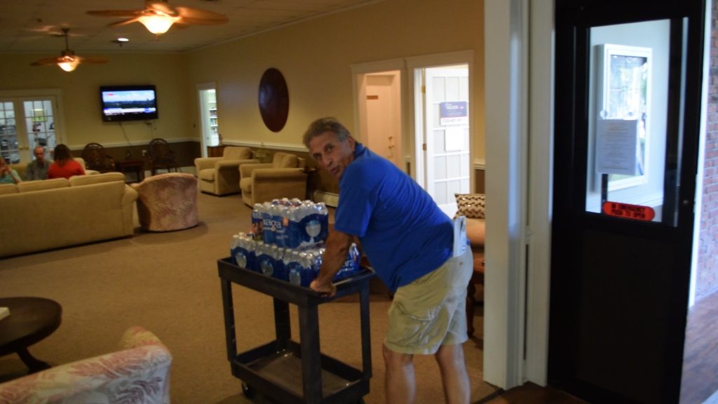 A volunteer brings water into the Greenbriar I clubhouse, Aug. 14, 2018. (Photo: Daniel Nee)