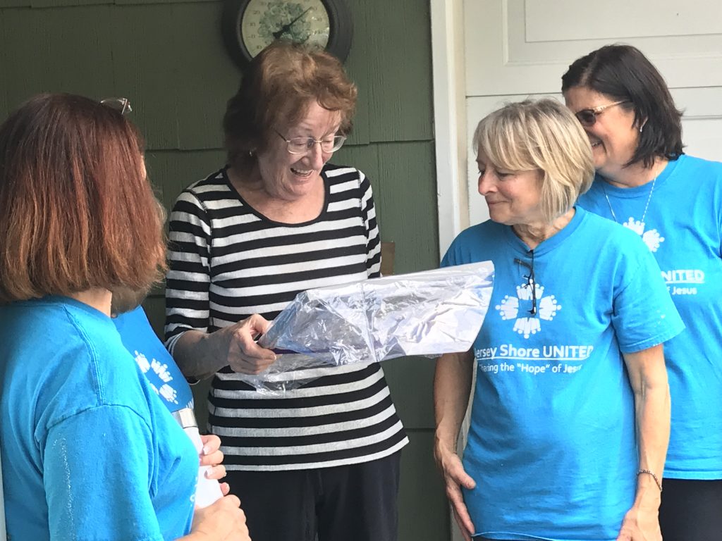 Renate Kupat receives a painting from the volunteers who helped her move back into her house in Brick's Greenbriar development, Oct. 4, 2018. (Photo: Daniel Nee)
