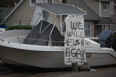 A boat in Brick's Shore Acres section the day after Superstorm Sandy struck with a message, "We Will Fish Again," attached. (Photo: Daniel Nee)