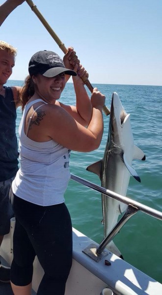 Nicole, a customer on the Queen Mary, shows off the largest catch of her life – a black tip shark! (Photo: Queen Mary)
