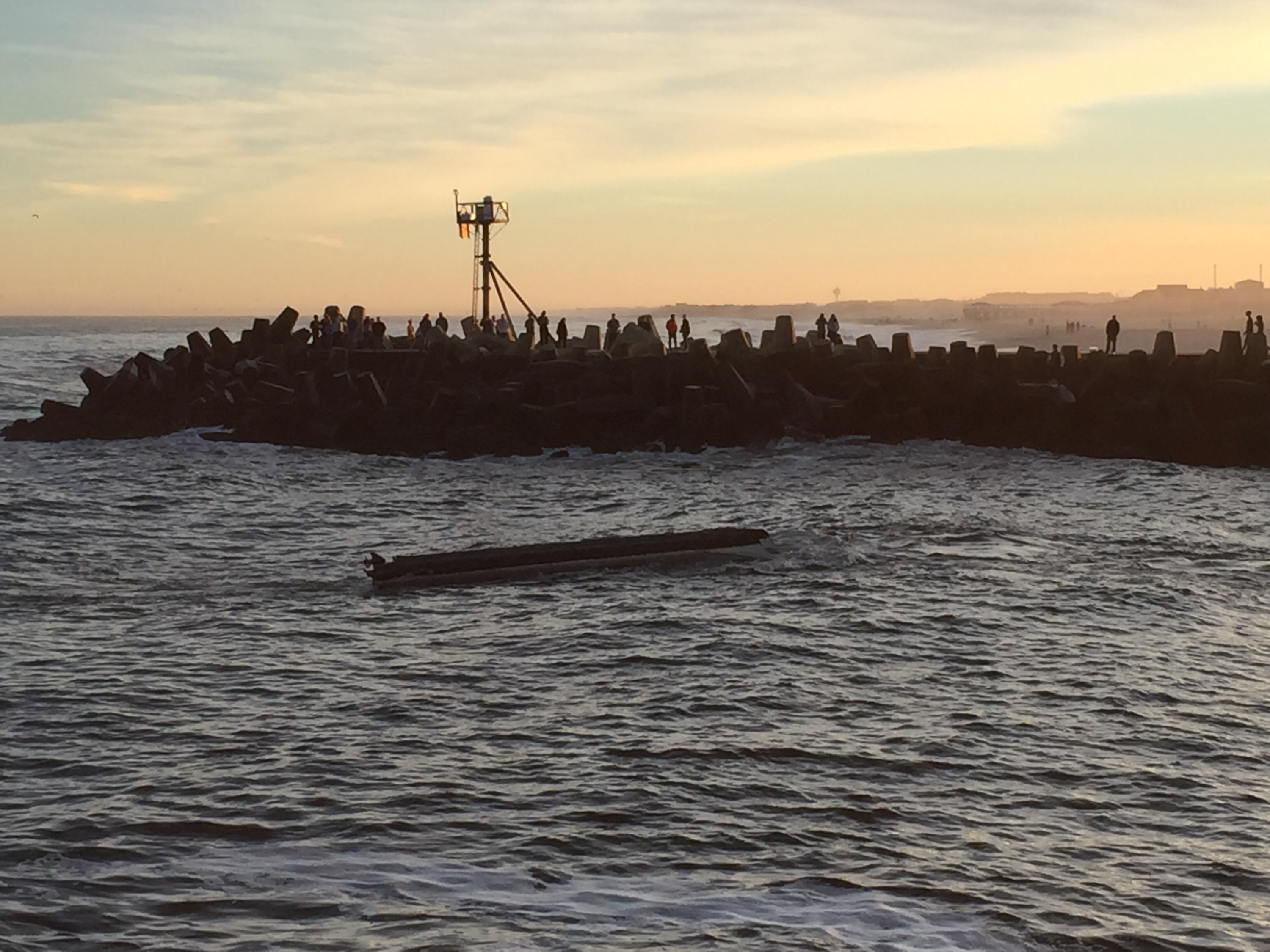 A pontoon boat that capsized off Manasquan Inlet is towed in. (Photo: Daniel Nee)