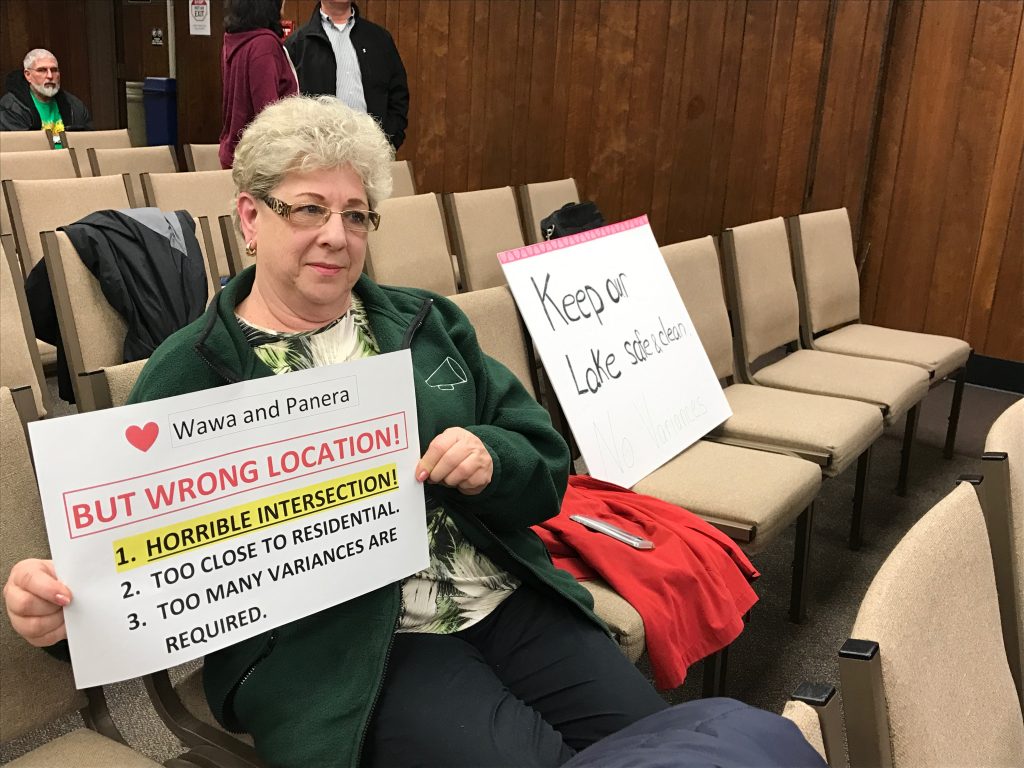 A Brick resident holds a sign opposing a Wawa and quick-serve resident being built off Route 70. (Photo: Daniel Nee)