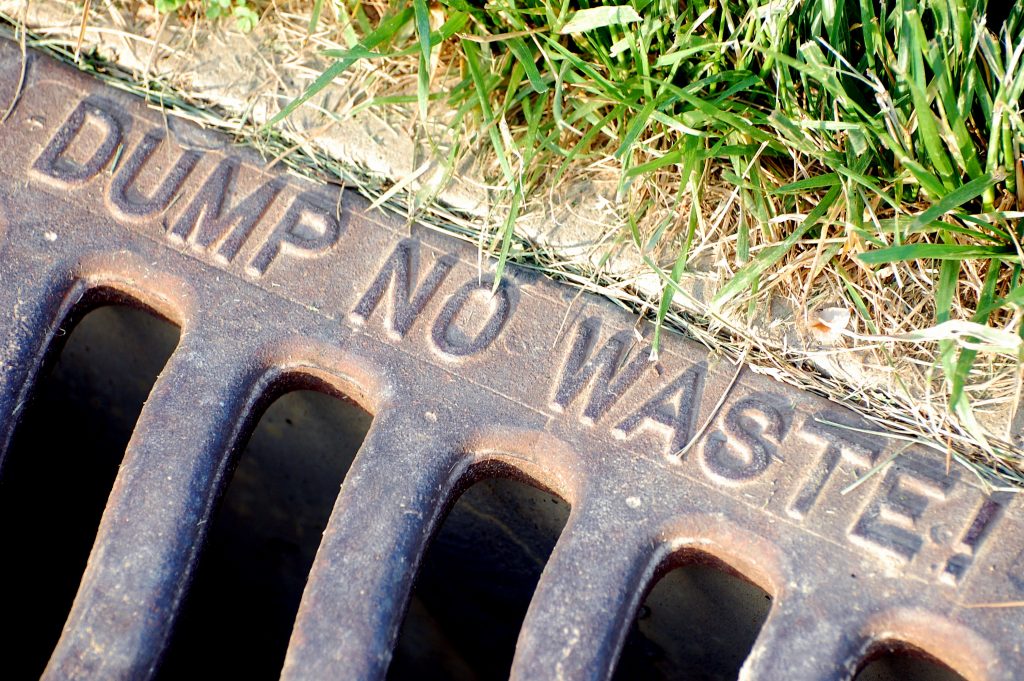A "Dump No Waste" inscription on a storm sewer grate. (Credit: Steve Snodgrass/ Flickr)