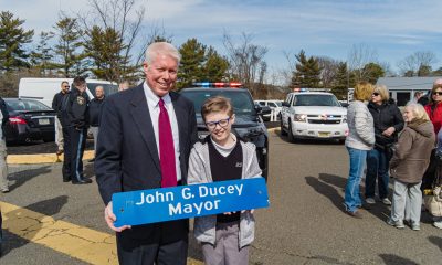 Brick Mayor John Ducey and his son, Jack, hold up his parking space sign following his last day in office, Feb. 27, 2023. (Photo: Daniel Nee)