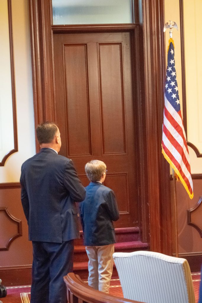 Jack Ducey, beside Kevin Starkey, leads the Pledge of Allegiance at his father's swearing-in ceremony, March 23, 2023. (Photo: Daniel Nee)