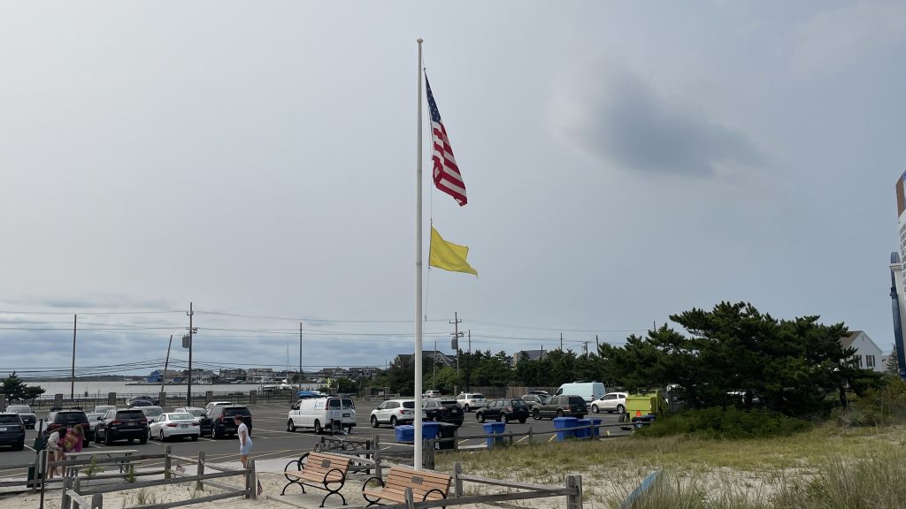 A single-yellow flag flies at Brick Beach III, Aug. 2023. (Photo: Shorebeat)